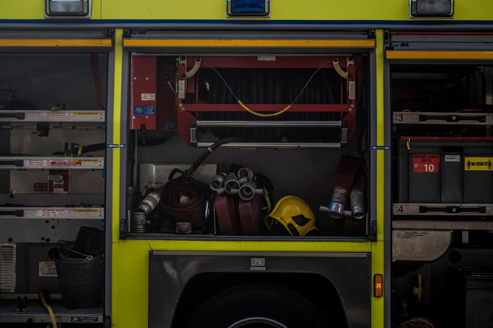 Motorist checking fuel gauge with emergency supplies in hand