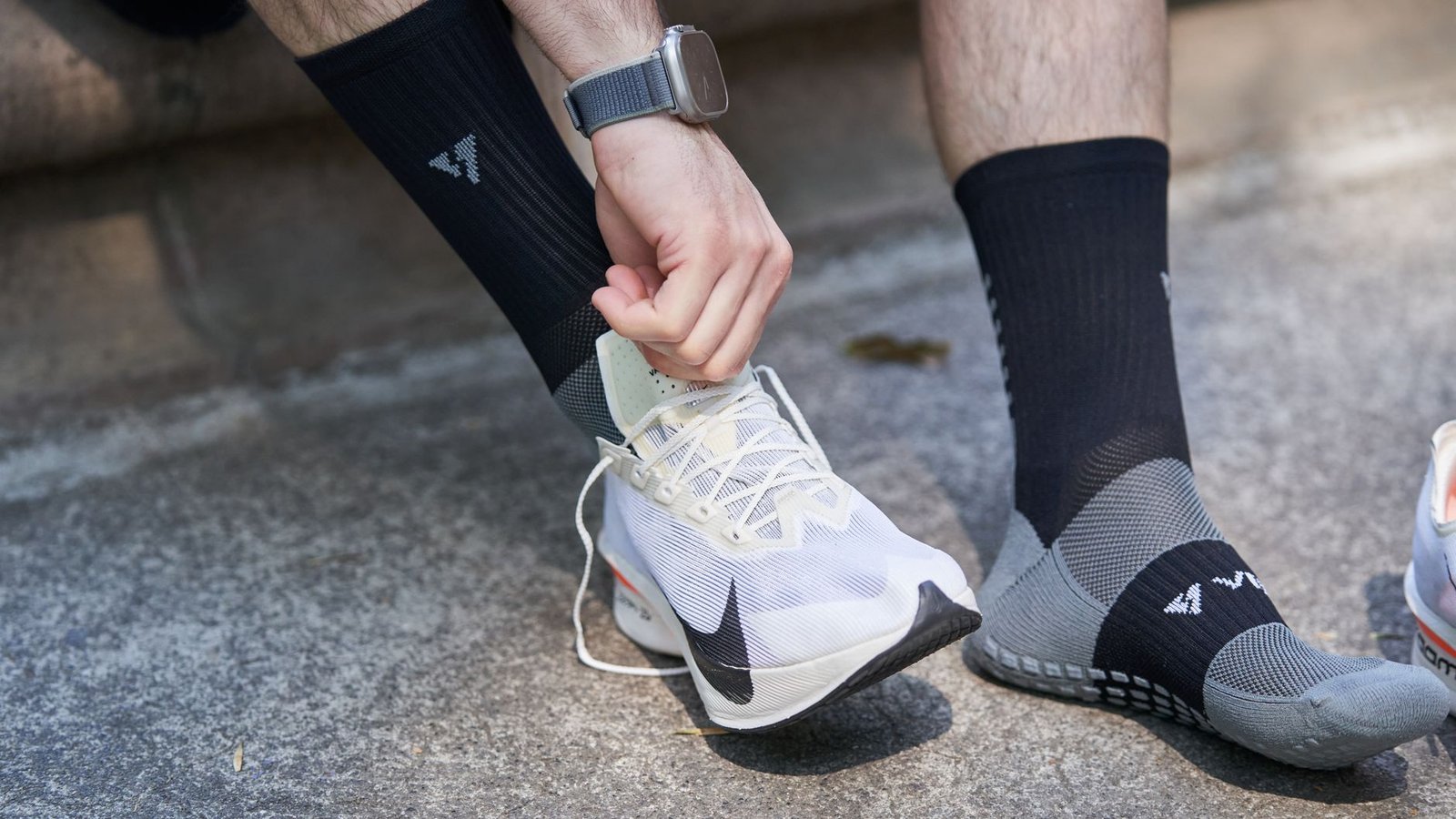 Runner comparing shoe fit using worn-in race socks