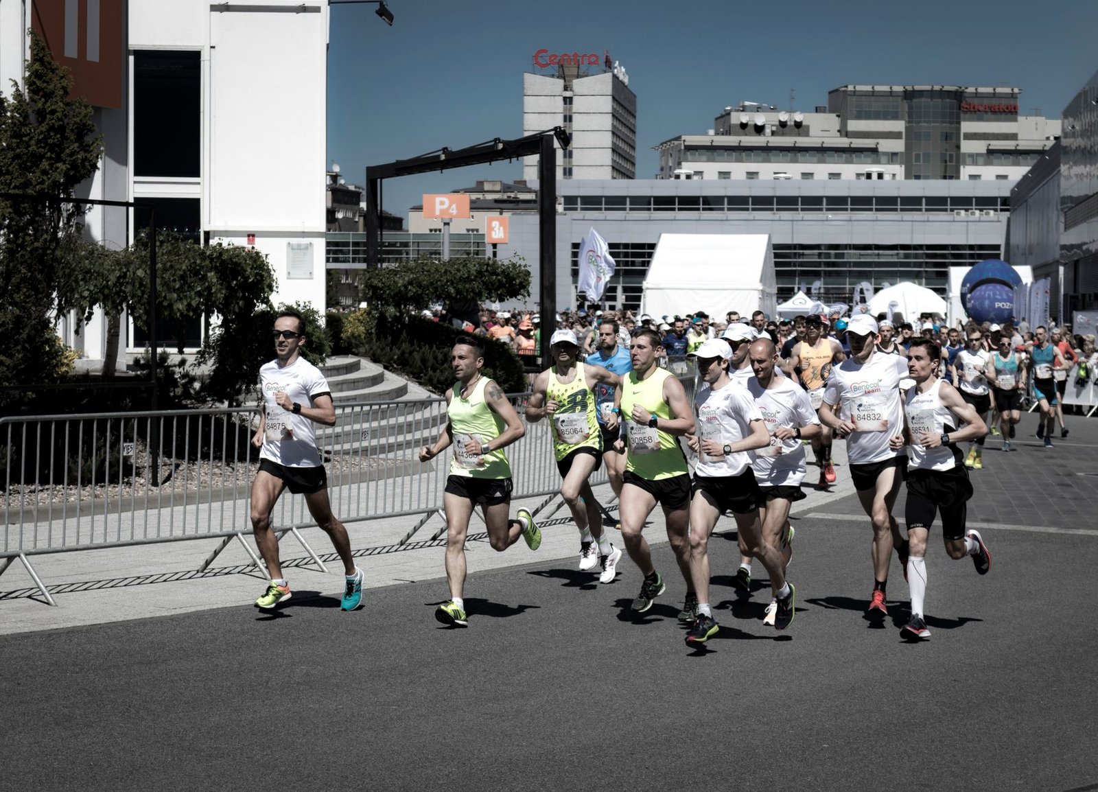 Coach guiding runners through warmup despite heavy spectator crowds