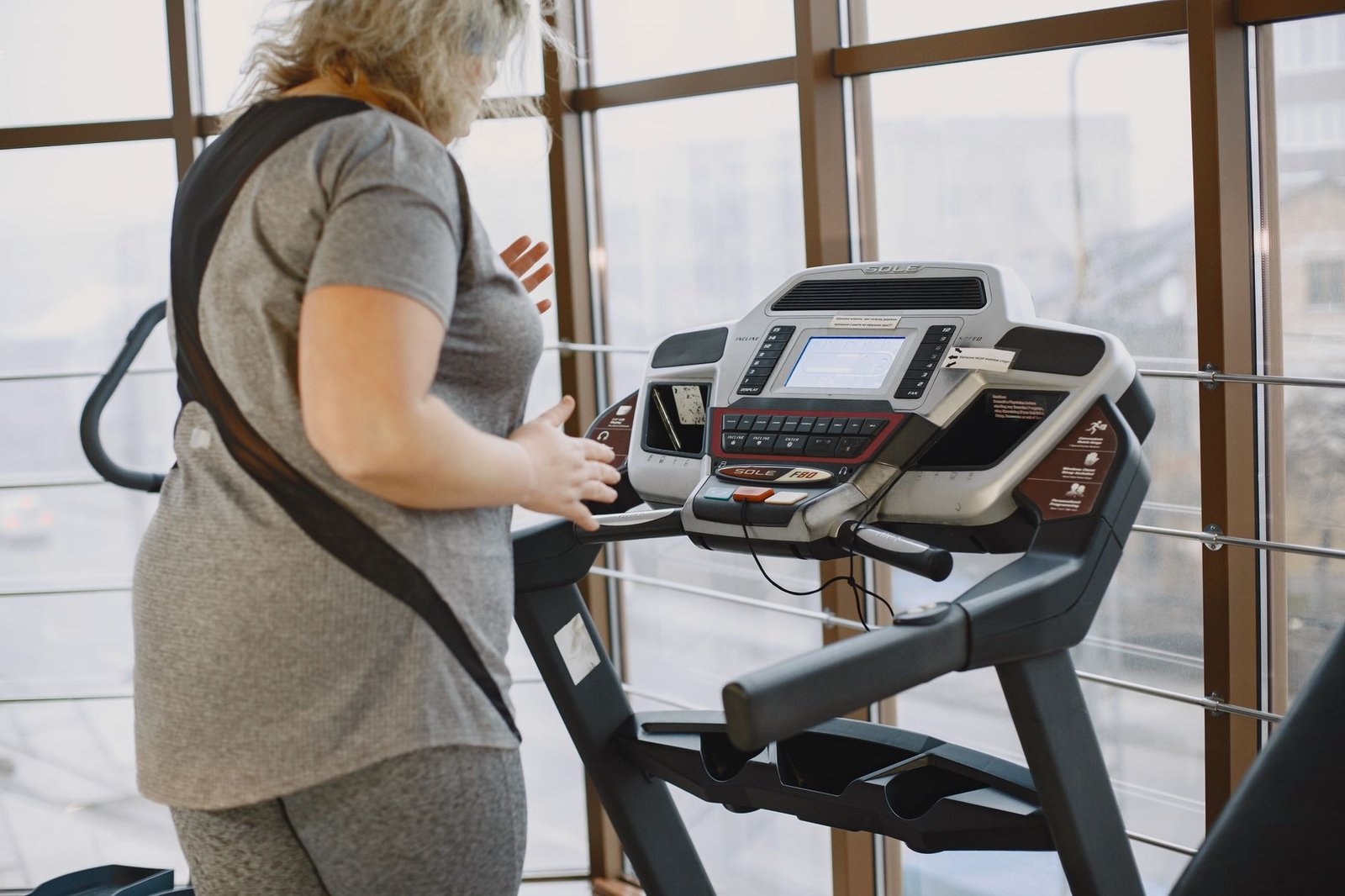 Close-up of treadmill control panel dialing incline settings